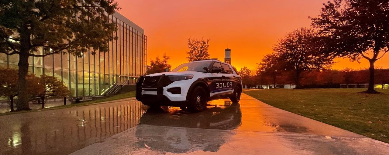 下雨天，钟楼和图书馆前，以夕阳为背景的警车